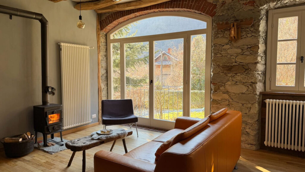 Sfeervol vakantie appartement in Valsesia met houtkachel, natuurstenen muren en groot panoramaraam in de bergen van Piemonte, Italië